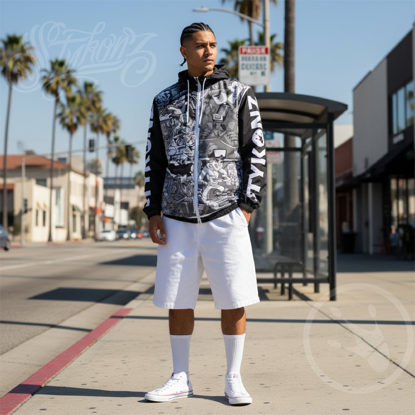 Man wearing a black and white jacket with graphic designs on a city street.